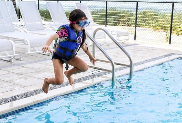 Child jumping in pool